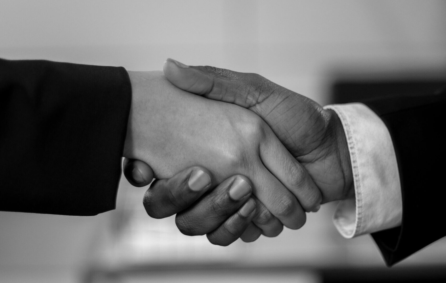 Close-up of a professional handshake in black and white, symbolizing agreement and partnership.